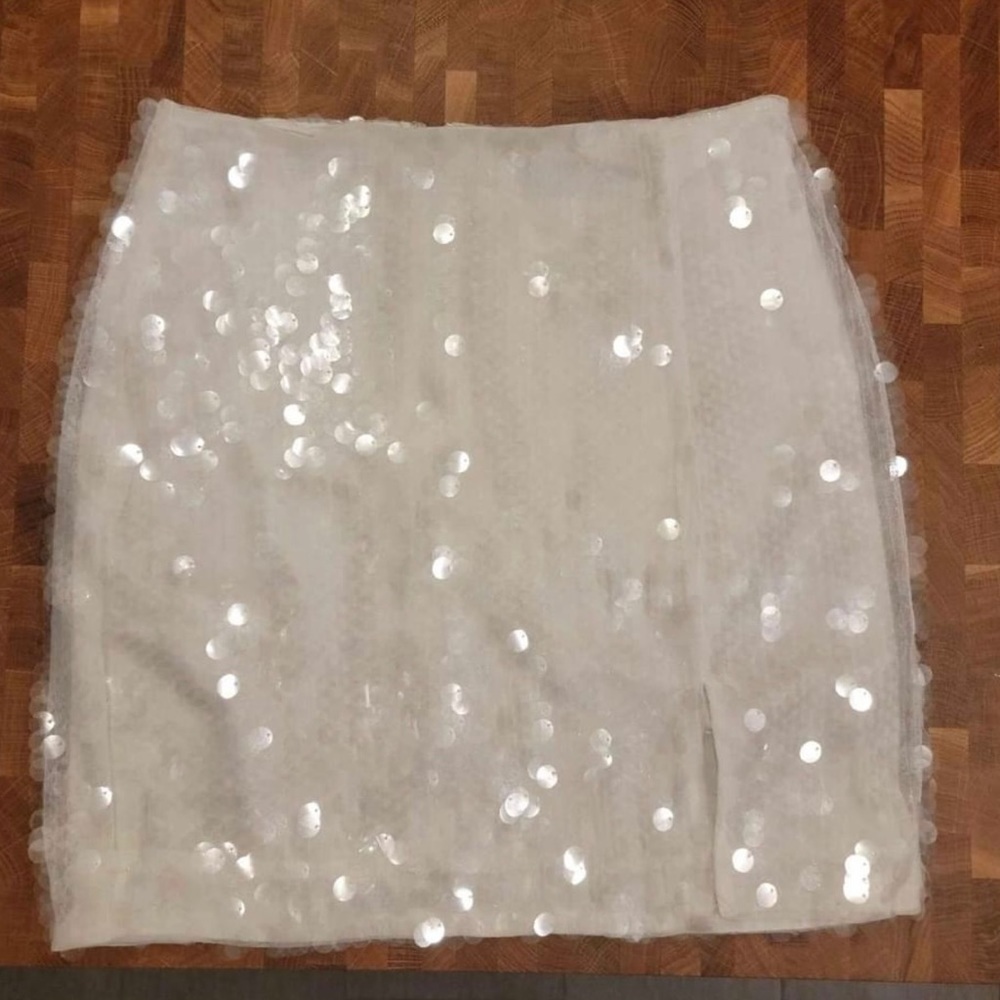 Off white, sequined mini skirt from Akira. Small slit in left leg. Size small.